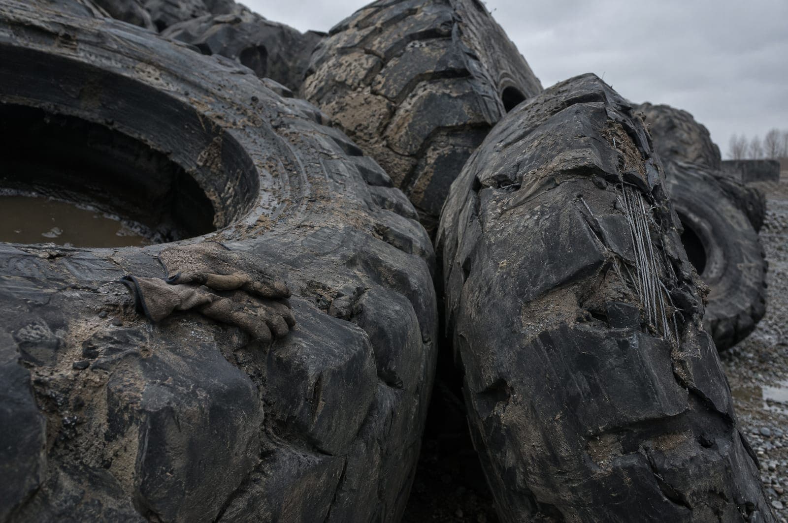 Scrap off-the-road tires, each taller than a person
